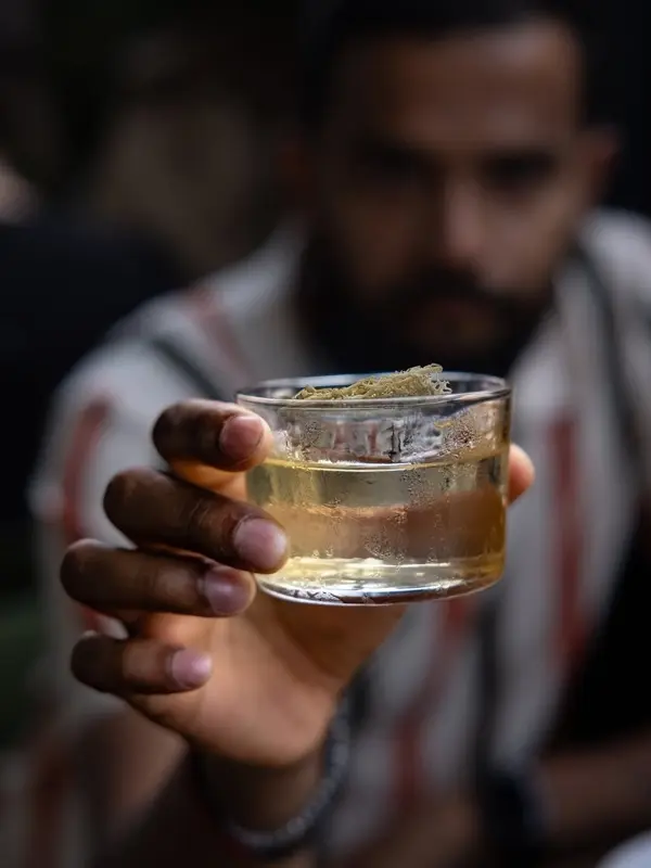 Cocktail being raised at Chupito, a Mexican bar in Vancouver featured by Michelin